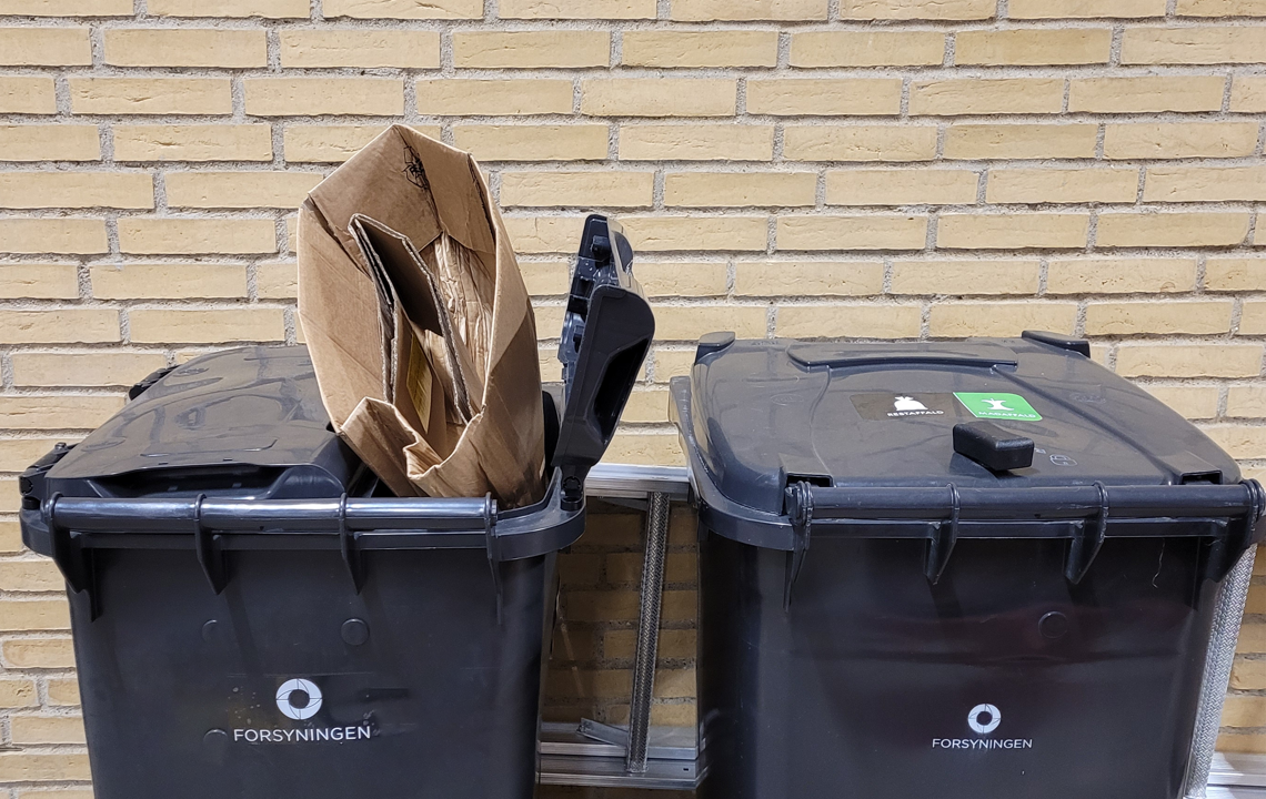 Stort pap fastklemt i affaldsbeholder