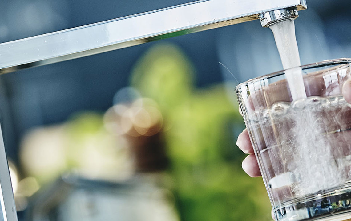 Vandglas bliver fyldt fra vandhane