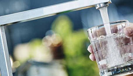 Vandglas bliver fyldt fra vandhane Vandglas bliver fyldt fra vandhane