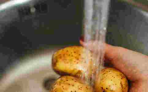 Kartofler skylles under vandhane