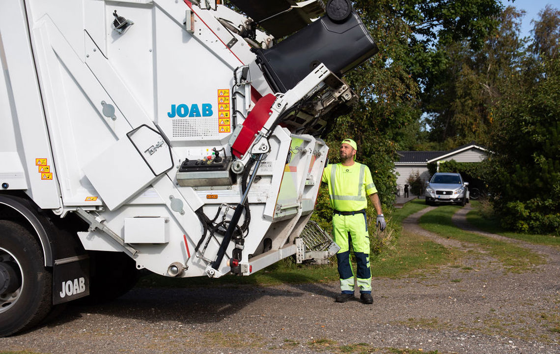 Skraldemand tømmer affaldsbeholdere  i sommerhusområde